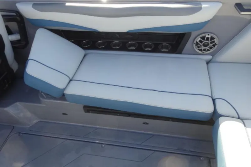 Slide: The Image of 2022 Axis T23 boat interior with blue and white cushioned seating and speaker. - 13