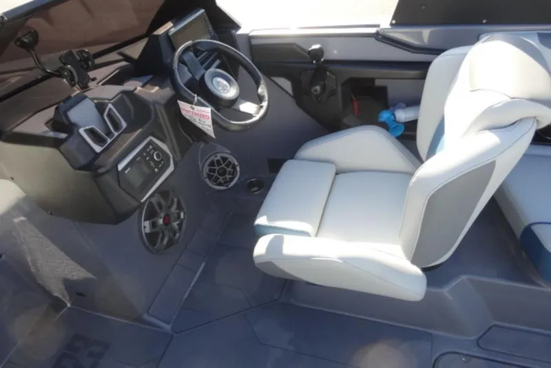 Slide: The Image of Interior of 2022 Axis T23 boat with steering wheel and white seating. - 8