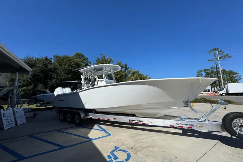 Slide: The Image of 2026 Cape Horn 34 XS boat on trailer, parked outdoors under clear blue sky. - 7