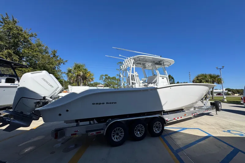 Slide: The Image of 2026 Cape Horn 34 XS boat on trailer, parked outdoors under clear blue sky. - 9