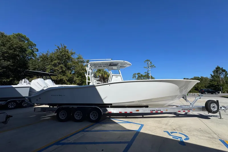 Slide: The Image of 2026 Cape Horn 34 XS boat on trailer, parked outdoors under clear blue sky. - 8