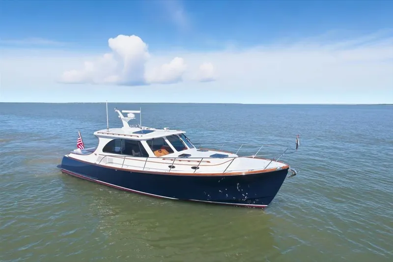 Slide: The Image of 2015 Hinckley Talaria 43 yacht cruising on open water under a clear blue sky. - 3