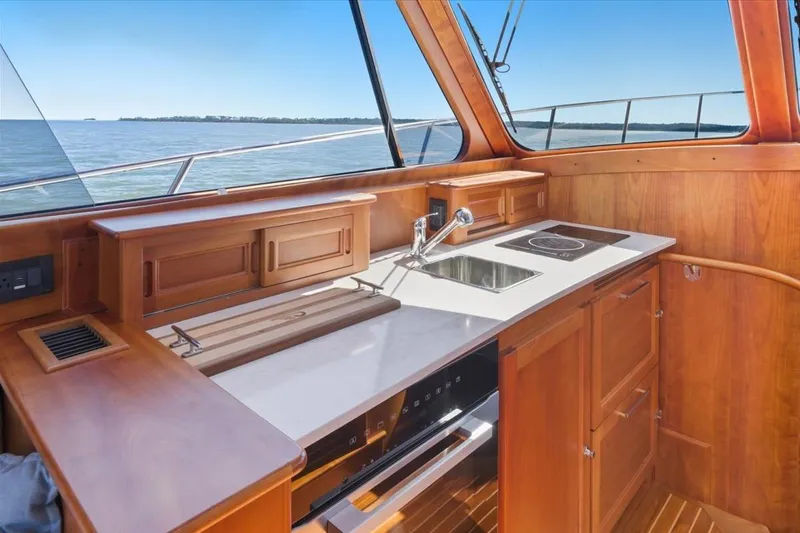 Slide: The Image of Interior of 2015 Hinckley Talaria 43 yacht with wooden cabinetry and modern kitchen amenities. - 11