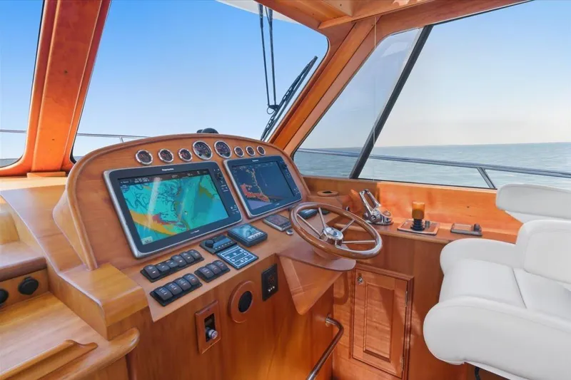 Slide: The Image of Helm of 2015 Hinckley Talaria 43 yacht with navigation screens and wooden dashboard. - 12
