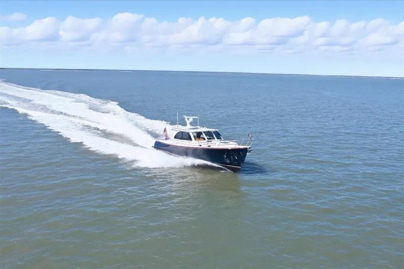 Slide: The Image of 2015 Hinckley Talaria 43 cruising on open water under a clear blue sky. - 2
