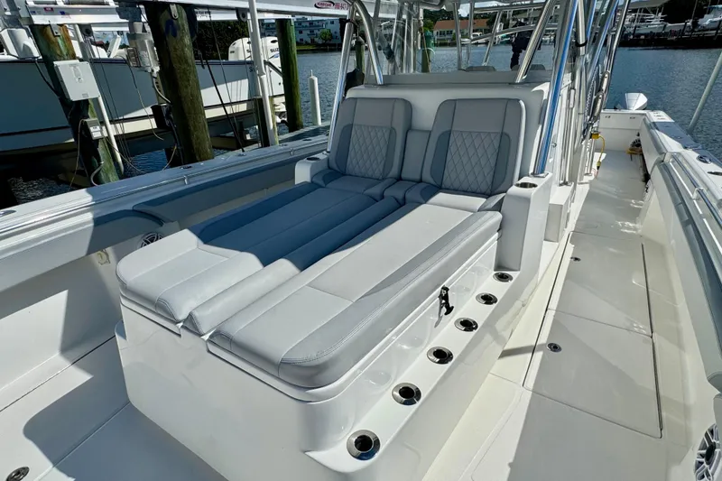 Slide: The Image of 2021 SeaHunter 41 CTS boat cruising on a calm waterway near a coastal town. - 5