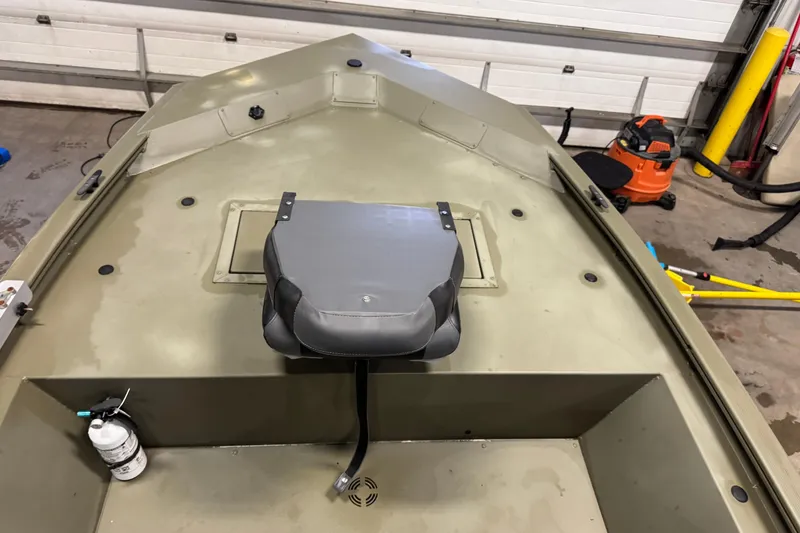 Slide: The Image of 2024 Tracker Grizzly 1648 SC boat interior with seat and storage compartment. - 10