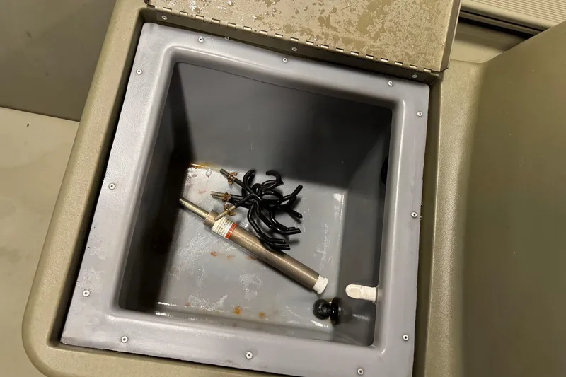 Slide: The Image of Open storage compartment in 2024 Tracker Grizzly 1648 SC boat with tools inside. - 11