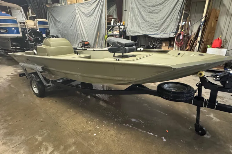 Slide: The Image of 2024 Tracker Grizzly 1648 SC boat on trailer in a garage setting. - 2