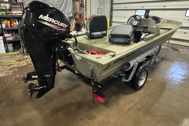 Slide: The Image of 2024 Tracker Grizzly 1648 SC boat with Mercury engine in a garage setting. - 3