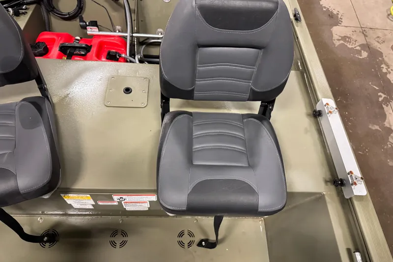 Slide: The Image of 2024 Tracker Grizzly 1648 SC boat interior with gray seating and red fuel tanks. - 5
