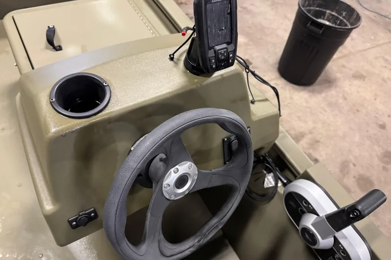 Slide: The Image of 2024 Tracker Grizzly 1648 SC boat console with steering wheel and controls. - 8