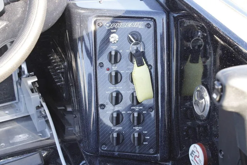 Slide: The Image of Control panel of 2025 Phoenix 921 ELITE boat with switches and steering wheel. - 25