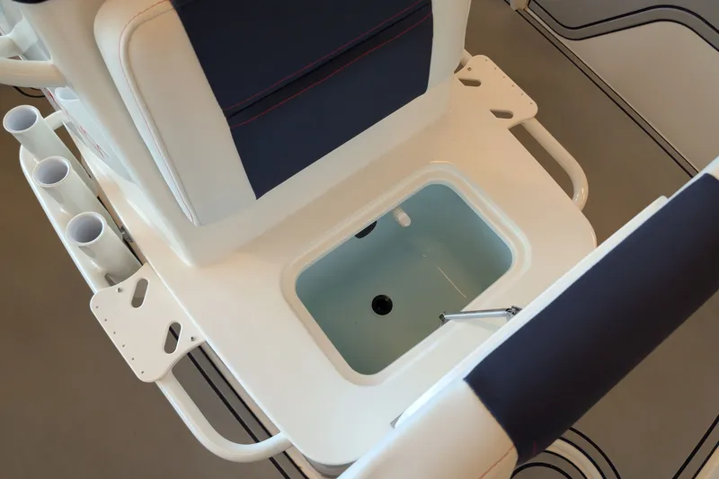Slide: The Image of 2026 Mako 18 Pro Skiff Patriot Edition boat interior with storage compartment and rod holders. - 10