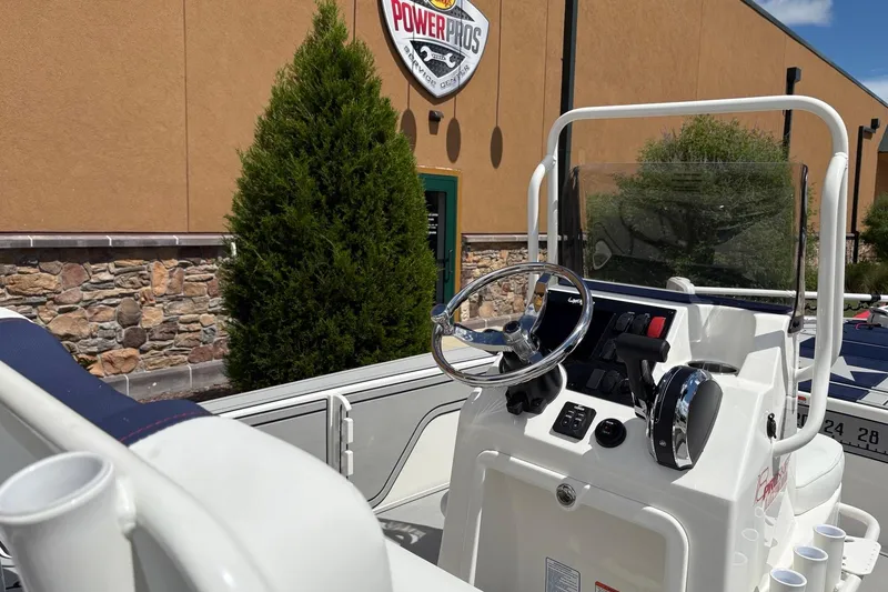 Slide: The Image of 2026 Mako 18 Pro Skiff Patriot Edition boat console with steering wheel and controls. - 89