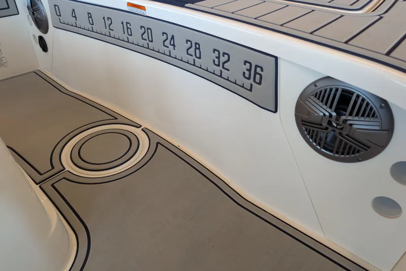 Slide: The Image of Interior of 2026 Mako 18 Pro Skiff Patriot Edition with ruler and speaker detail. - 9