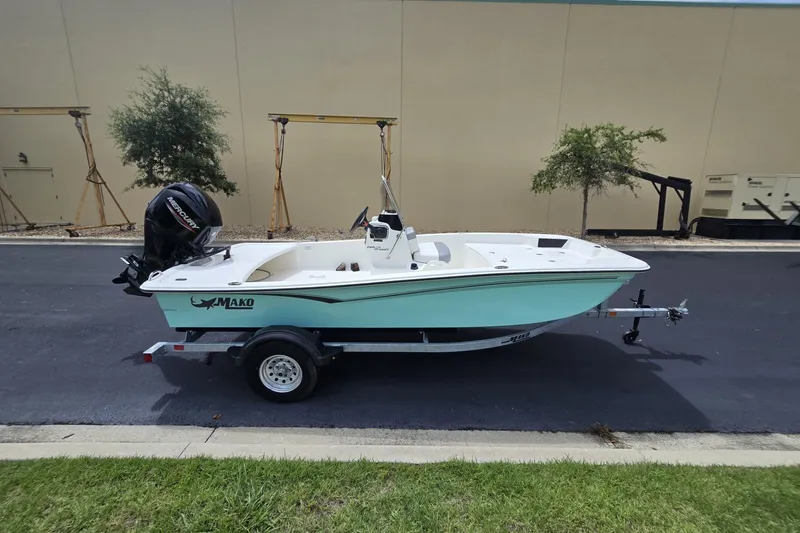 Slide: The Image of 2026 Mako Pro Skiff 15 CC boat on trailer, parked outdoors. - 1