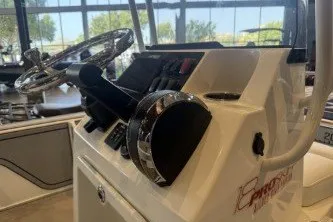 Slide: The Image of 2026 Mako 18 Pro Skiff Patriot Edition boat console with steering wheel and controls. - 12