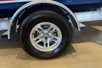 Slide: The Image of 2026 Mako 18 Pro Skiff Patriot Edition trailer wheel, close-up view. - 9