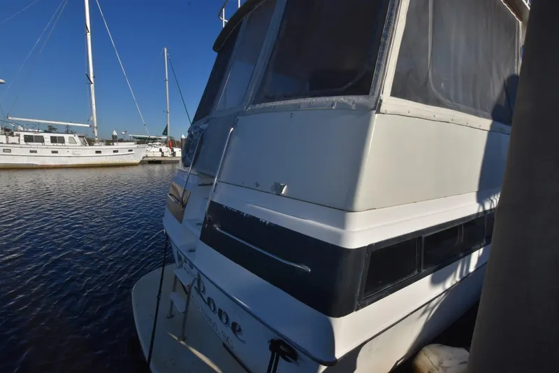 Slide: The Image of 1993 Ocean Yachts 44 Aft Cabin docked at marina, with sailboats in background. - 3
