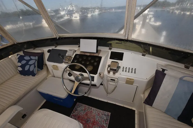 Slide: The Image of 1993 Ocean Yachts 44 Aft Cabin helm with steering wheel, controls, and cushioned seating. - 7