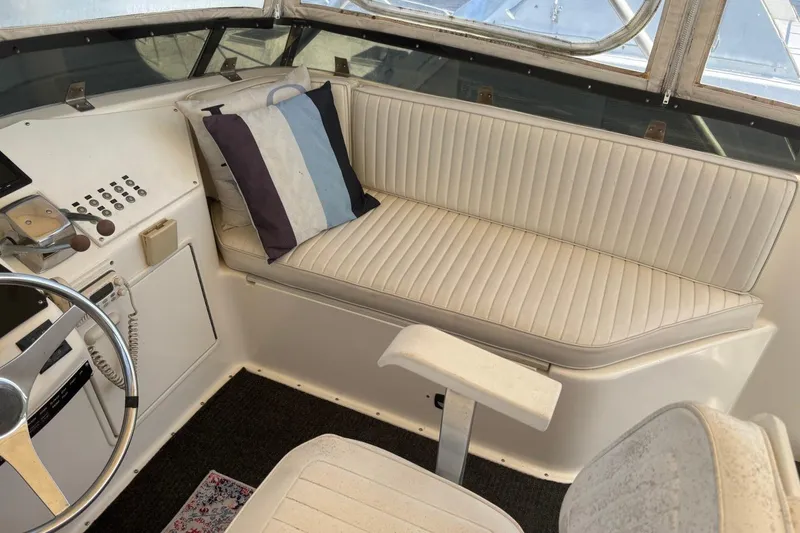 Slide: The Image of 1993 Ocean Yachts 44 Aft Cabin helm with white seating and striped pillow. - 8