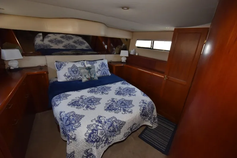 Slide: The Image of 1993 Ocean Yachts 44 Aft Cabin bedroom with nautical-themed bedding and wooden cabinetry. - 27