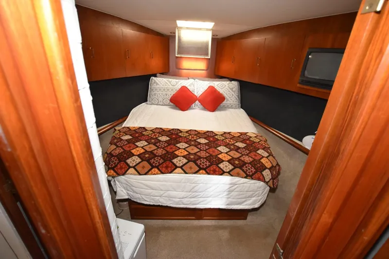 Slide: The Image of 1993 Ocean Yachts 44 Aft Cabin bedroom with cozy bed and wooden cabinetry. - 17