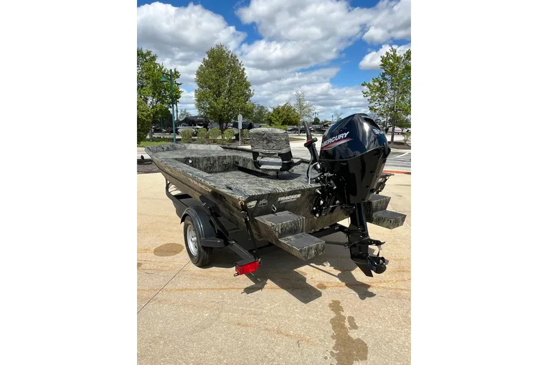 Slide: The Image of 2026 Tracker Grizzly 1654 T Sportsman boat with Mercury engine, parked outdoors. - 7