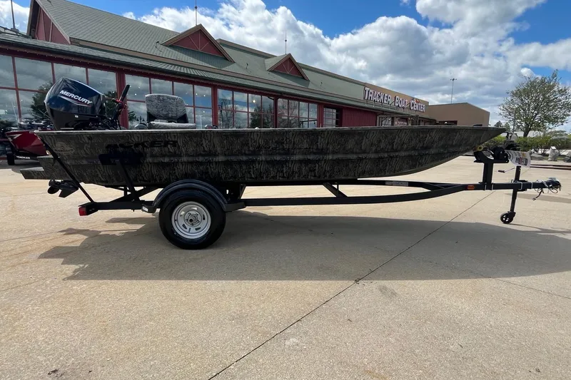 Slide: The Image of 2026 Tracker Grizzly 1654 T Sportsman boat on trailer, parked outdoors. - 9