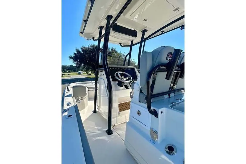 Slide: The Image of 2026 Ranger 2360 Bay boat interior with steering console and seating, under clear blue sky. - 11