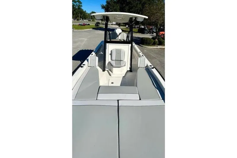 Slide: The Image of 2026 Ranger 2360 Bay boat interior with seating and console, parked outdoors. - 16