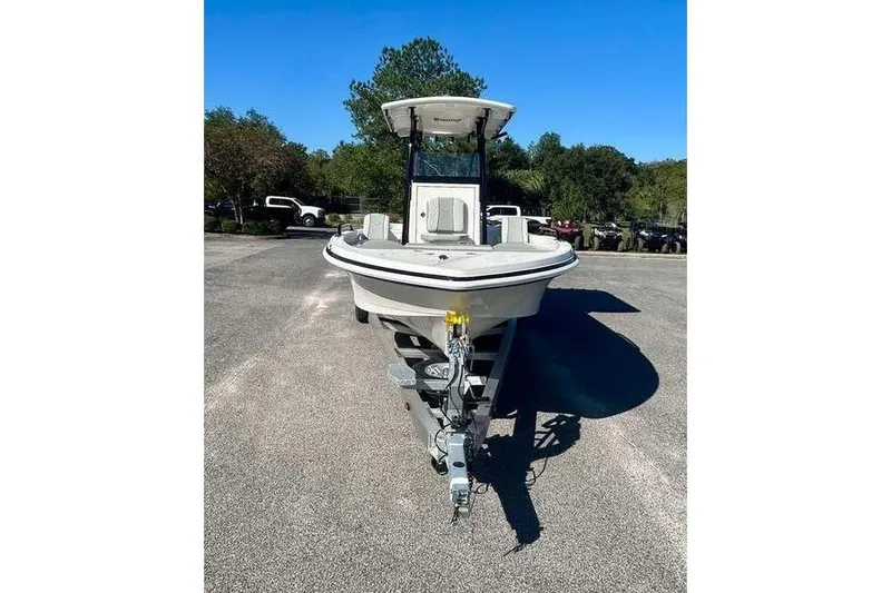 Slide: The Image of 2026 Ranger 2360 Bay boat on trailer, parked outdoors under clear blue sky. - 2