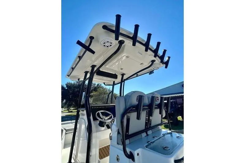 Slide: The Image of 2026 Ranger 2360 Bay boat with T-top and rod holders under clear blue sky. - 8