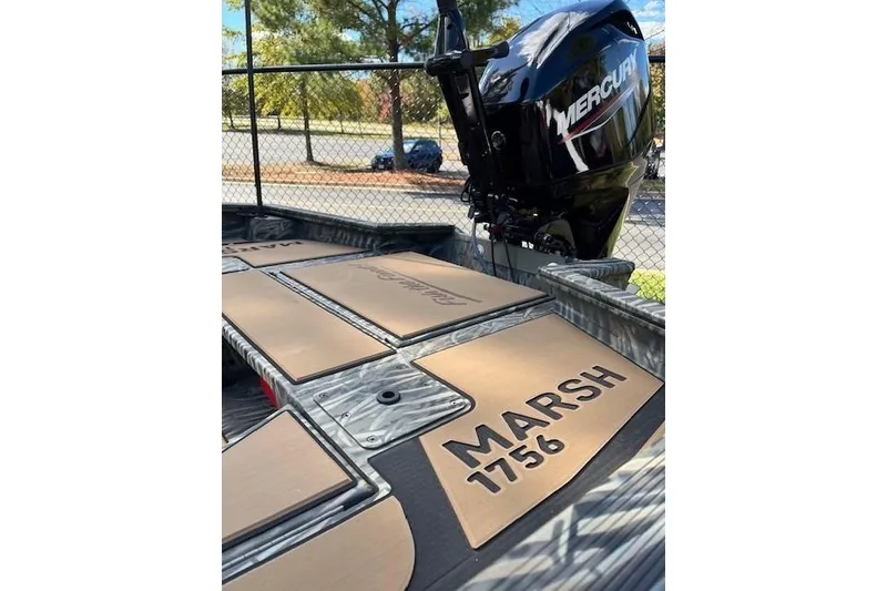 Slide: The Image of 2026 Tracker Grizzly 1756 T Marsh boat with Mercury engine, parked outdoors. - 47