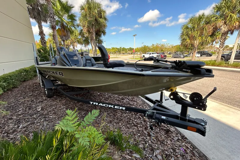 Slide: The Image of 2026 Tracker Pro Team 175 boat on trailer, parked near palm trees. - 2