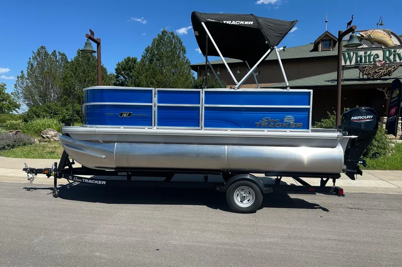 The Image of 2026 Sun Tracker Party Barge 16 DLX pontoon boat on trailer, parked outdoors. - 0