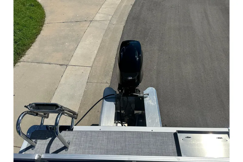 Slide: The Image of 2026 Sun Tracker Party Barge 16 DLX pontoon boat with motor, parked on pavement. - 13