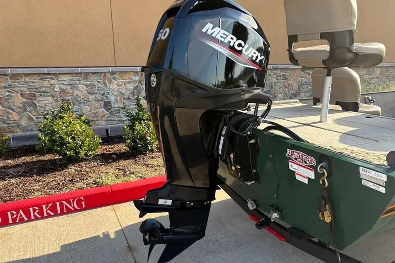 Slide: The Image of 2026 Tracker Bass Tracker Classic Limited with Mercury outboard motor in a parking area. - 6