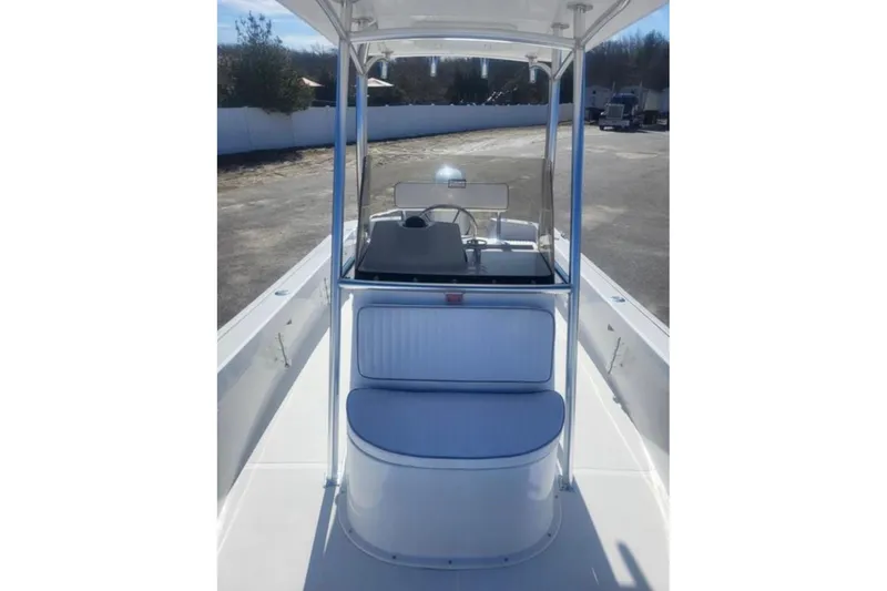 Slide: The Image of 2024 Maritime 233 Defiant boat interior with seating and console, docked outdoors. - 4