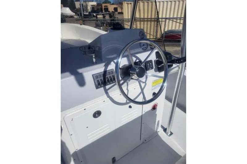 Slide: The Image of 2024 Maritime 233 Defiant boat helm with steering wheel and control panel. - 5