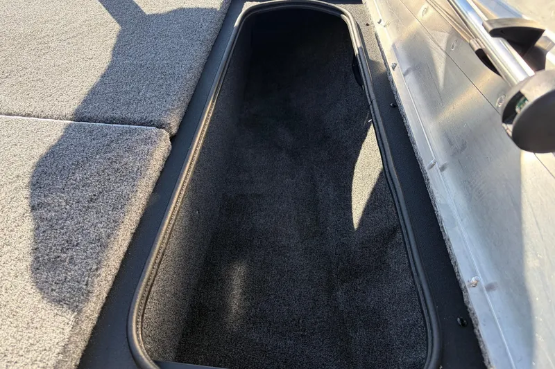 Slide: The Image of Storage compartment of 2026 Tracker Pro Team 175 Crappie Edition boat, featuring carpeted interior. - 18