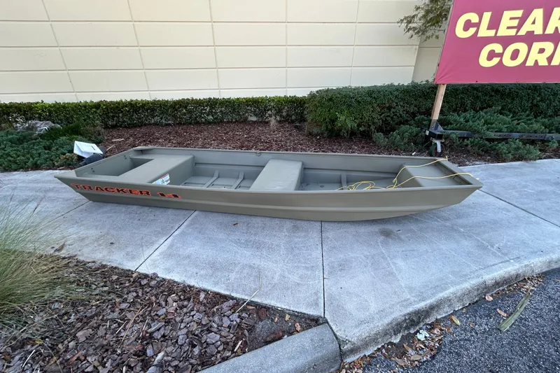 Slide: The Image of 2026 Tracker Grizzly 14 Jon boat displayed outdoors on concrete pavement. - 2
