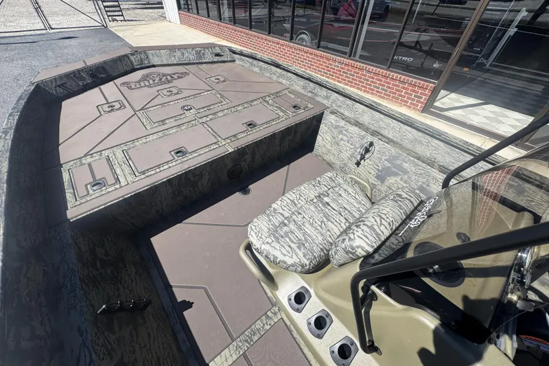 Slide: The Image of 2026 Tracker Grizzly 2072 CC boat interior with camouflage seating and storage compartments. - 12