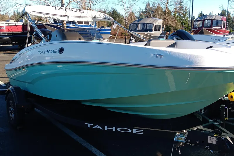 Slide: The Image of 2026 Tahoe T16 boat with turquoise hull on trailer, parked outdoors. - 64