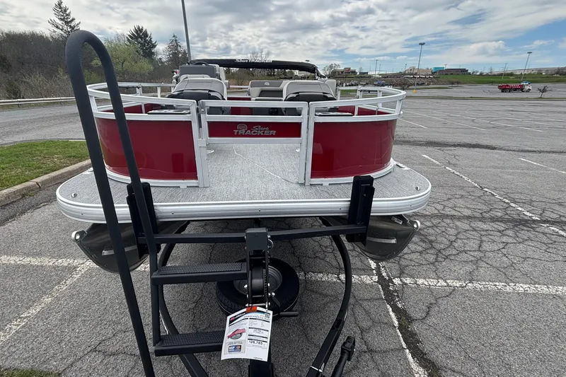 Slide: The Image of 2026 Sun Tracker Bass Buggy 16 XL Select pontoon boat in parking lot. - 2