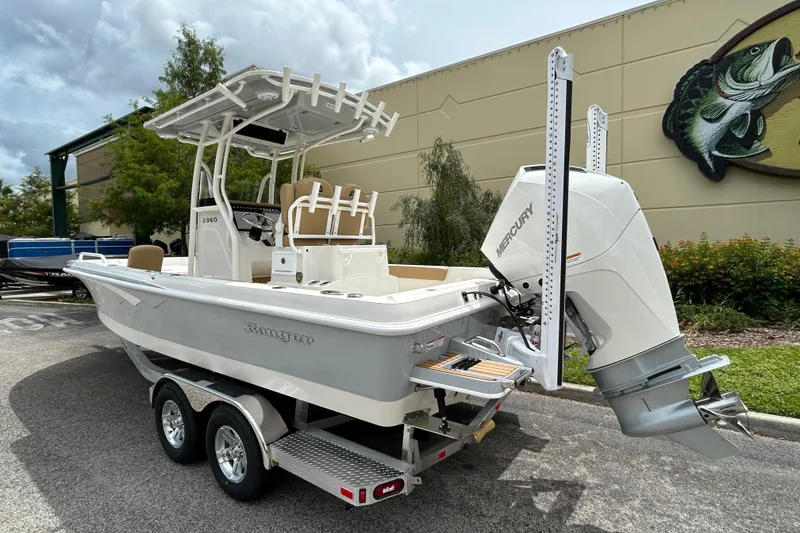Slide: The Image of 2026 Ranger 2360 Bay boat with Mercury engine, parked outdoors. - 2