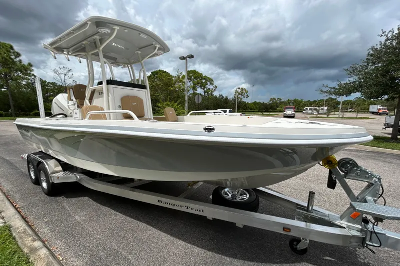 Slide: The Image of 2026 Ranger 2360 Bay boat on trailer, parked outdoors under cloudy sky. - 5