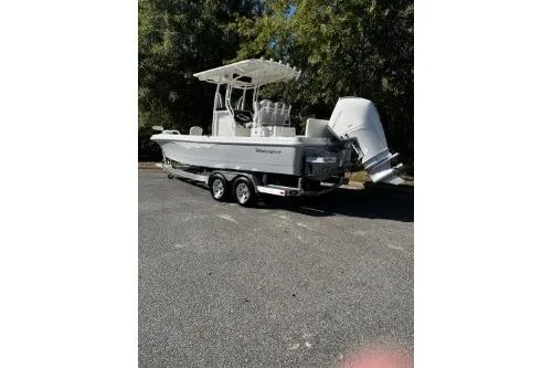 Slide: The Image of 2026 Ranger 2360 Bay boat on trailer, parked outdoors, with trees in the background. - 2