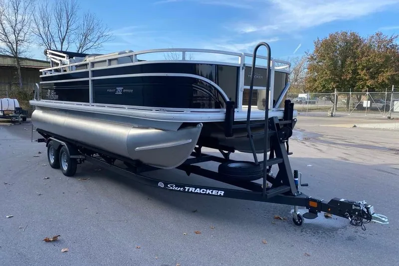 Slide: The Image of 2026 Sun Tracker Fishin' Barge 20 DLX pontoon boat on trailer, parked outdoors. - 103